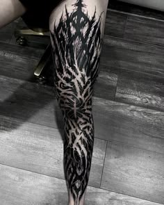 a man's leg covered in black and white ink with an intricate design on it