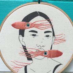 a woman's face is drawn on a piece of wood with red thread in it