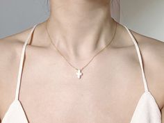 This stunning necklace features a unique cross-shaped baroque pearl pendant, which is sure to make a statement. The irregular shape of the pearl gives it a natural, organic look, while the lustrous surface reflects light beautifully. The pearl is suspended from a delicate make of 14k gold filled, adding to the elegance of the piece. Perfect for both casual and formal occasions, this necklace is a versatile addition to your jewelry collection. Whether you wear it to work or to a special event, it will add a touch of sophistication and individuality to your outfit. This cross-shaped baroque pearl necklace also makes a thoughtful and unique gift for someone special.  Material: Cross-shaped Baroque Freshwater Pearl, 14k gold plated chain  Length: 15 inches. Simply leave a message at checkout s White Cross Necklace With Clavicle Chain, White Cross Pendant Necklace With Clavicle Chain, White Cross Necklace With Pearl Pendant, Pearl Chain Cross Pendant Necklace Gift, Gift Pearl Chain Cross Pendant Necklace, Gold Cross Necklace With Pearl Chain, Gold Cross Necklace With Pearl Pendant, Elegant White Cross Necklace Pendant, Elegant White Cross Pendant Necklace