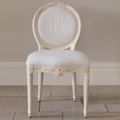 a white chair sitting on top of a tiled floor