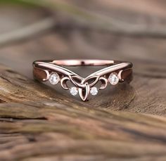 a close up of a ring on top of a piece of wood with diamonds in it