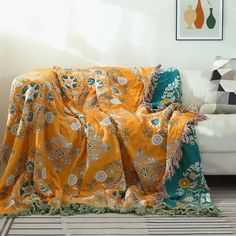 a couch covered in an orange and green blanket