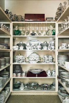 the shelves are full of dishes and plates on them, including one that is covered with glassware