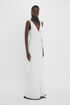 Elegant midi dresses are a signature of the Victoria Beckham brand. Exclusively reimagined in Ivory for the new season, the V-Neck Gathered Waist Gown has a provocative deep-V neckline, playfully low scooped back and graceful tie detail that falls from neckline to mid-thigh. The hourglass silhouette is emphasised by pleated details at the waist and ruching at the hip, while a contrasting black pleated hemline adds a contemporary punctuation. Victoria Beckham Exclusive V-Neck Gathered Waist Floor Leather Scarf, Size 12 Uk, Hourglass Silhouette, Elegant Midi Dresses, Floor Length Gown, Punctuation, Midi Dresses, Victoria Beckham, New Season