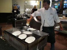 a man cooking food on top of a grill