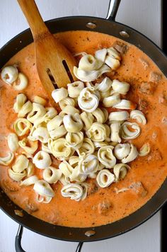 a pan filled with pasta and sauce on top of a stove