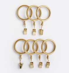 six pairs of gold metal rings with hooks on each side and two sets of earrings hanging from them