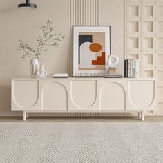 a living room with an art piece on the sideboard and a rug in front of it