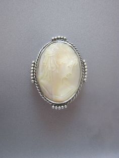 This vintage carved Mother of Pearl shell cameo is set in silver metal with a decorative frame.  1.75 inch length. There are no cracks or chips to the shell. Oval Silver Cameo Brooch, Decorative Frame, Cameo Brooch, Pearl Shell, Frame Decor, Mother Of Pearl, Favorite Jewelry, Brooch Pin, Brooches