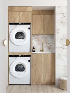 the washer and dryer are separated by cabinets in this modern laundry room with wood flooring