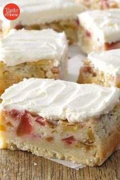 several pieces of cake sitting on top of a wooden table with white frosting and strawberries