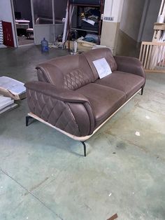 a brown leather couch sitting on top of a hard wood floor