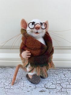 a stuffed mouse wearing glasses and a scarf