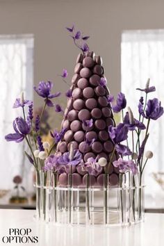 there is a cake made out of candy and purple flowers in the vases on the table