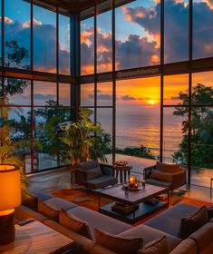 a living room filled with lots of furniture next to a large window overlooking the ocean