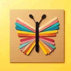 a butterfly made out of popsicle sticks on top of a yellow background with the words,