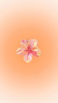 a pink flower floating in the air on an orange background