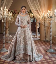 a woman in a wedding dress standing next to a chandelier