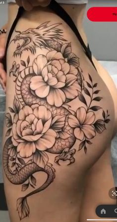 a woman's stomach with flowers and a snake tattoo on the side of her body