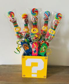 a box filled with candy and lollipops on top of a wooden table