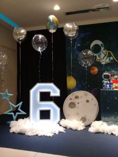 the number six is surrounded by balloons, stars and other decorations in front of a backdrop