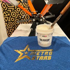 a blue shirt with the words metro stars on it next to a paintbrush and brush