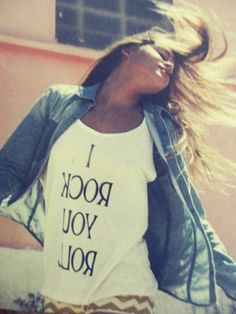 a woman wearing a t - shirt that says i rock you roll with her hair in the wind