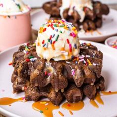 a white plate topped with chocolate cookies covered in frosting and sprinkles