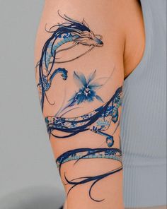 a woman's arm with blue flowers and swirls on the back of it