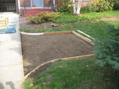 an empty yard with a brick walkway in the middle