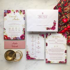 the wedding stationery is laid out on top of each other, along with two gold rings