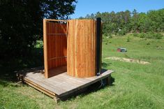 a wooden outhouse sitting in the middle of a field