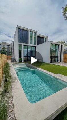 a house with a pool in front of it and grass on the ground next to it