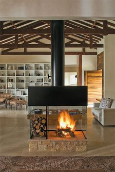 a living room filled with furniture and a fire place in the middle of it's fireplace