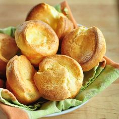 a white bowl filled with fried pastries on top of a green cloth