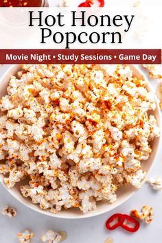 a white bowl filled with popcorn next to a red pair of scissors on top of a table