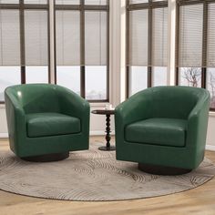 two green chairs sitting on top of a rug in a living room next to windows