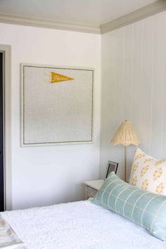 a white bed sitting in a bedroom next to a lamp