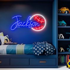 a child's bedroom with blue walls and neon lights that spell out the name jackson