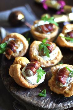 small appetizers are arranged on a wooden platter