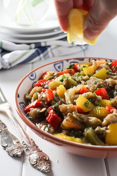 a bowl full of food sitting on top of a white table next to silverware