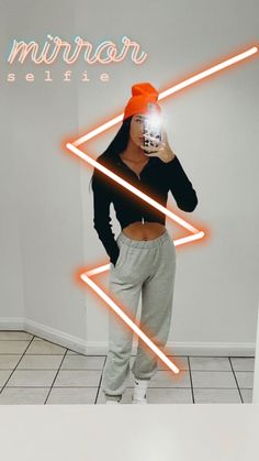 a woman taking a selfie in front of a mirror with neon lights behind her