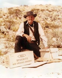 a man sitting on top of a box in the desert