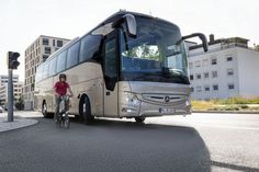 a man riding a bike next to a bus