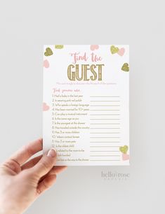 someone holding up a card with the words find the guest written on it in gold foil