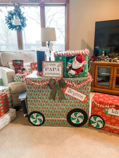 christmas presents are stacked on top of each other in front of a window with a holiday theme