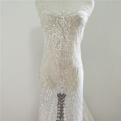 the back of a white wedding dress with beading and sequins on it