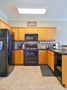 a kitchen with wooden cabinets and black appliances