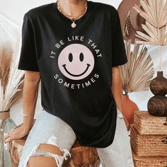 Black Crew Neck T-shirt With Smiley Face, Relaxed Fit Smiley Face Top For Loungewear, Black Smiley Face Crew Neck T-shirt, Smiley Face Top For Loungewear, Black Crew Neck Top With Smiley Face, Black Smiley Face Crew Neck Top, Cute T-shirt With Slogan For Lounging, Everyday Relaxed Fit Top With Smiley Face, Relaxed Fit Smiley Face Top For Everyday