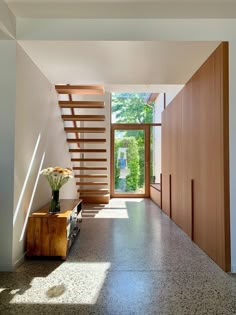 an open hallway with wooden stairs leading up to the second floor